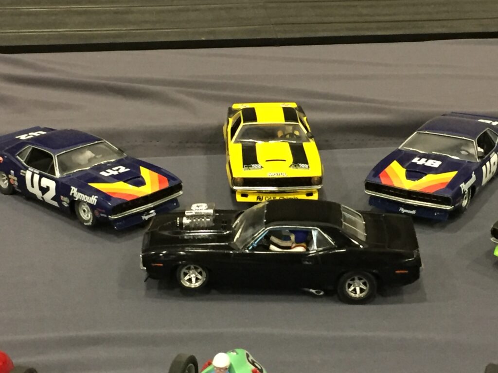 Real photo of four Dodge Chargers diecast cars at a diecast convention